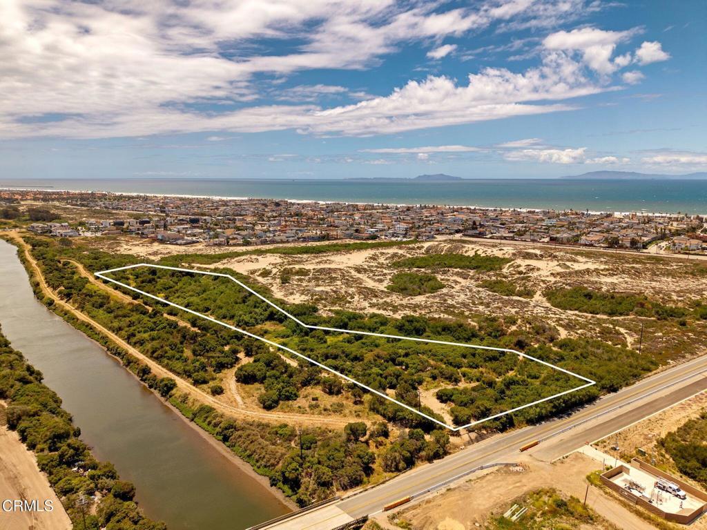 Coastal land parcel outlined in white, between a canal and road near the ocean.