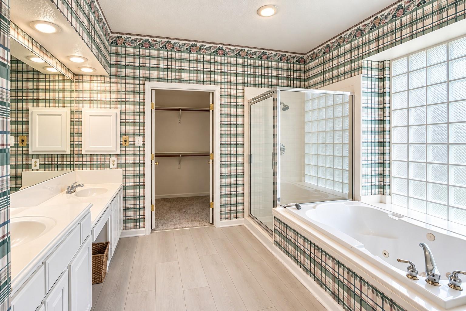 Bathroom with plaid tile, a glass-block window, soaking tub, and double vanity.