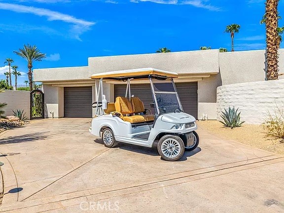 Single-story desert home with a white golf cart parked in the driveway.