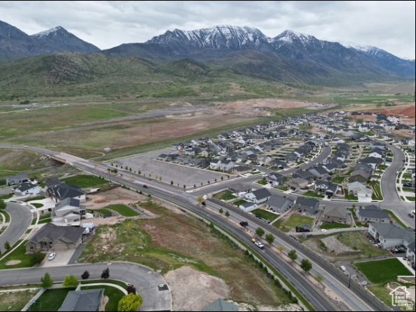Aerial view of a Santaquin neighborhood beside open land, with snowcapped mountains beyond.