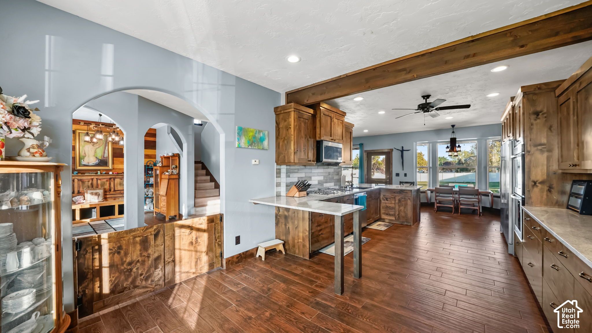 Kitchen with warm wood cabinetry, a large stone island, and an adjoining dining area.
