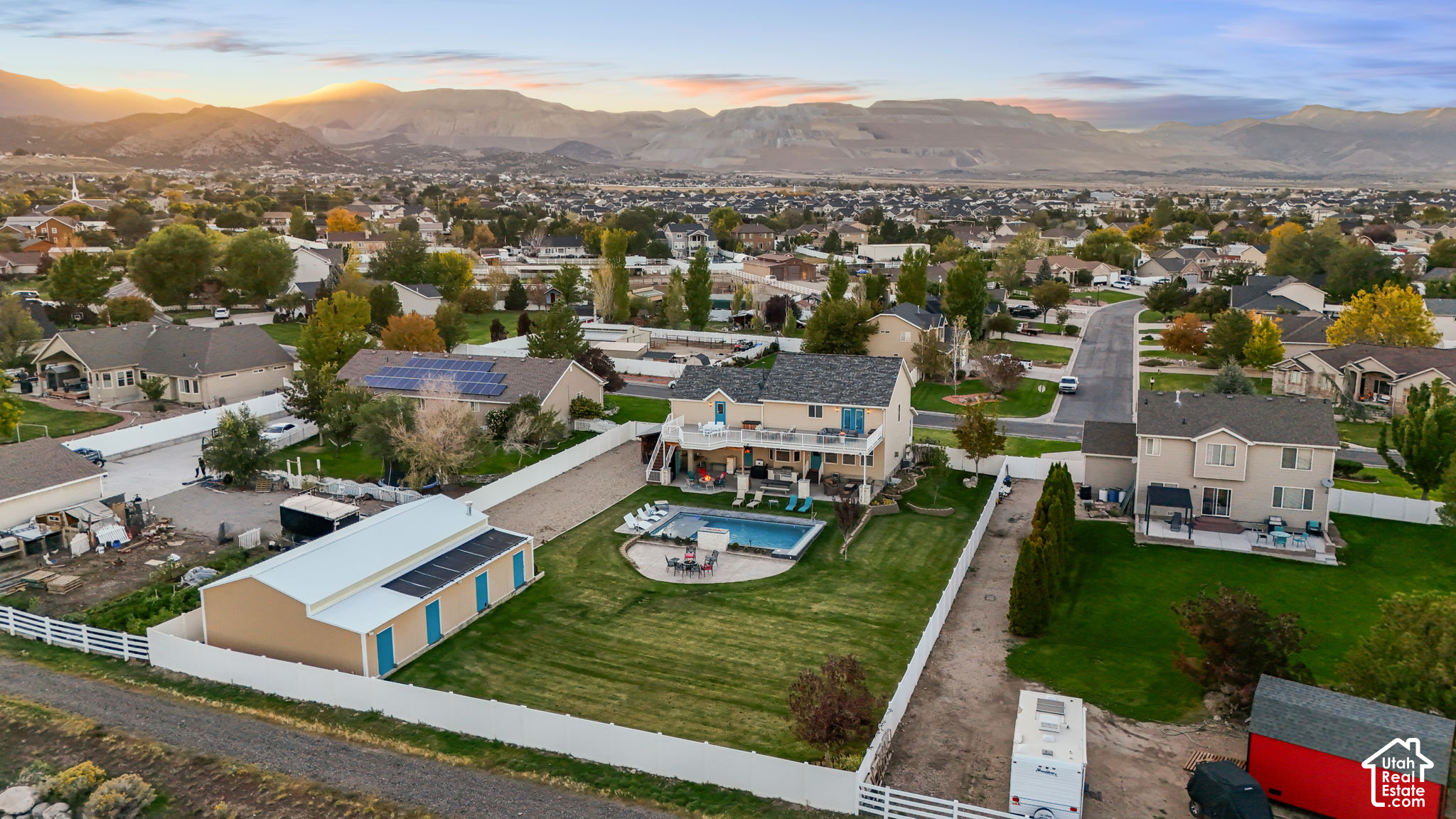 Aerial view of a Herriman home with a backyard pool and mountain views.