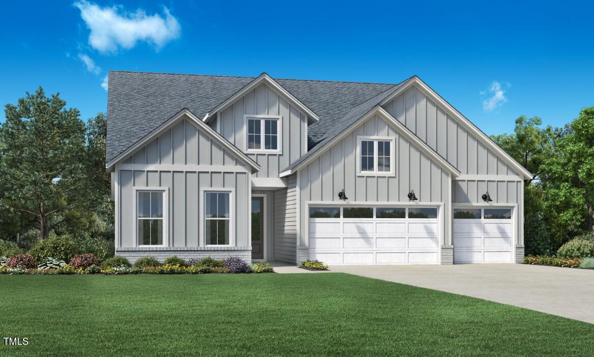 Gray two-story home with several gables, three garage doors, and a broad green lawn.