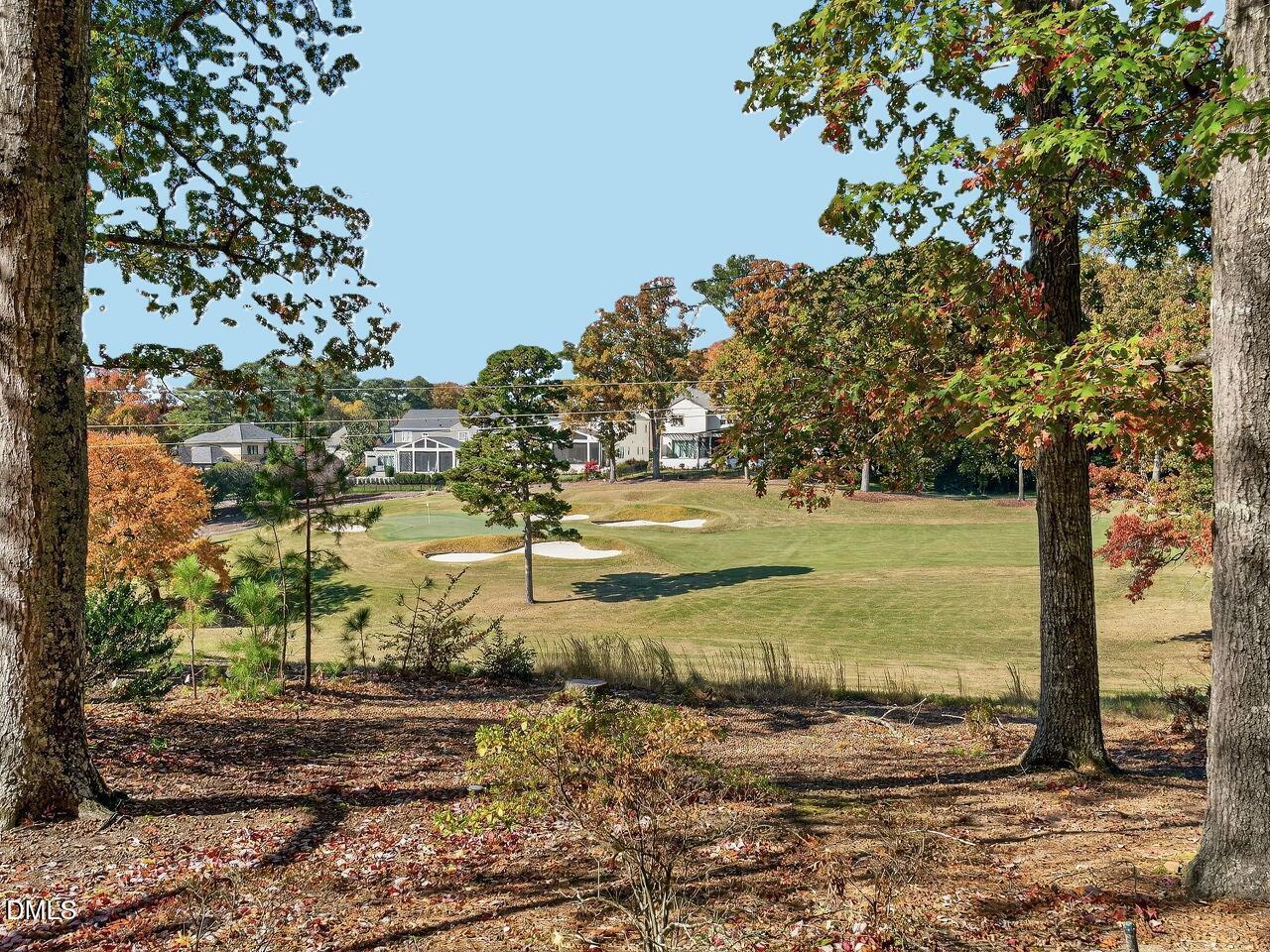 Golf course framed by autumn trees, with homes beyond the fairway.