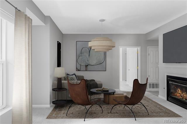 Living room with brown leather chairs, a gray sofa, patterned rug, and fireplace.