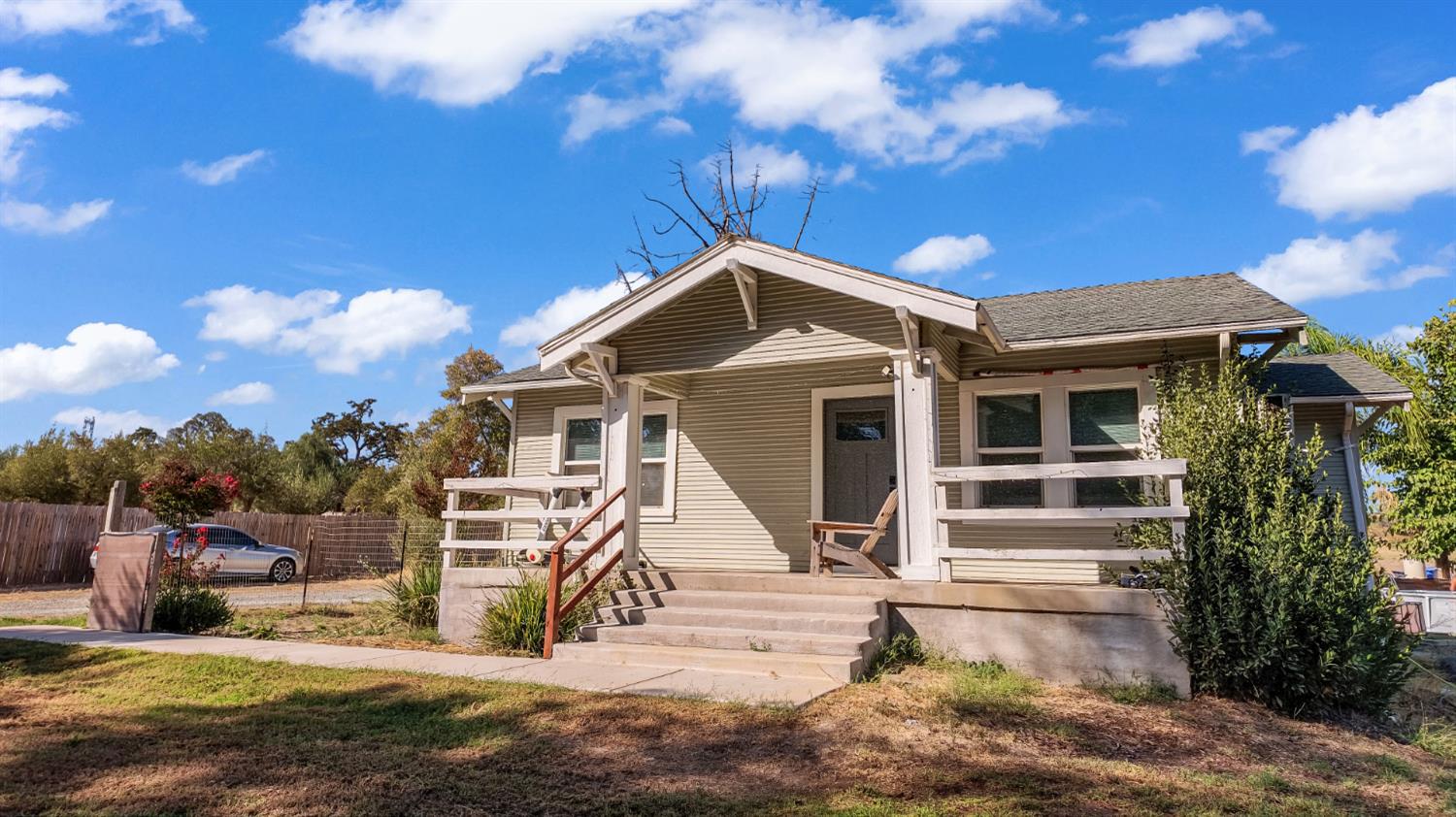 Single-story house with a covered porch and broad concrete front steps.