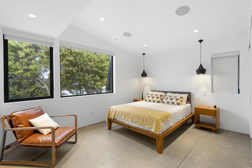 Spacious bedroom with large windows and minimalist furnishings