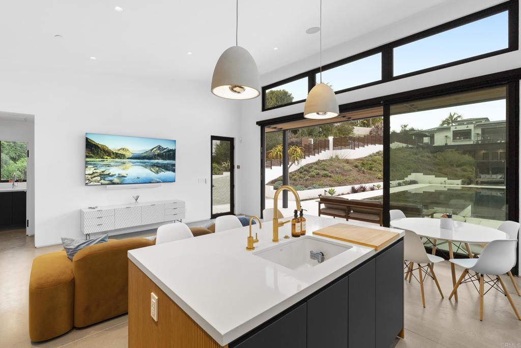 Sleek designer kitchen with island, pendant lights, and panoramic windows