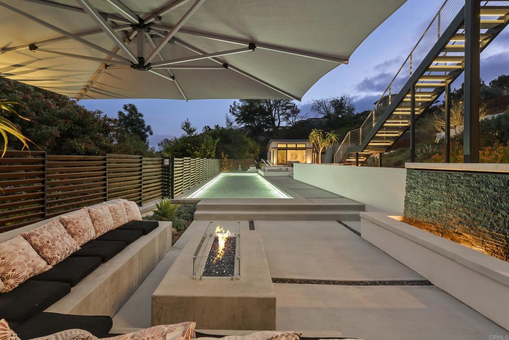 Outdoor lounge with pool, firepit, and modern privacy fencing