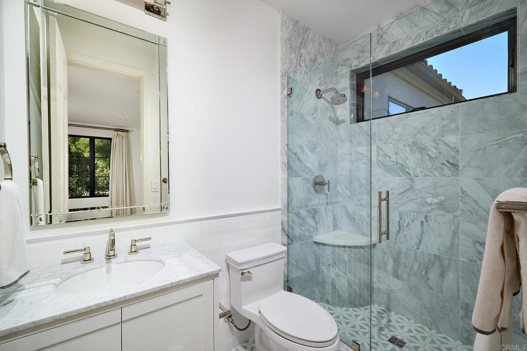 bedroom with corner windows and an attached bathroom
