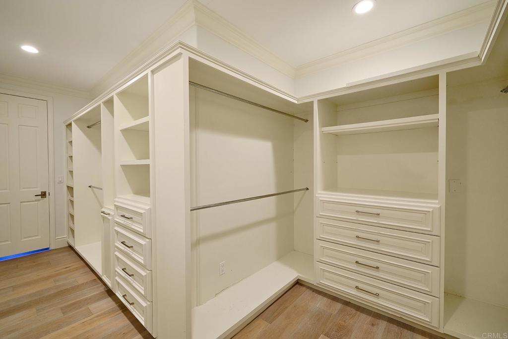 Large walk-in closet with custom built-ins and shelving