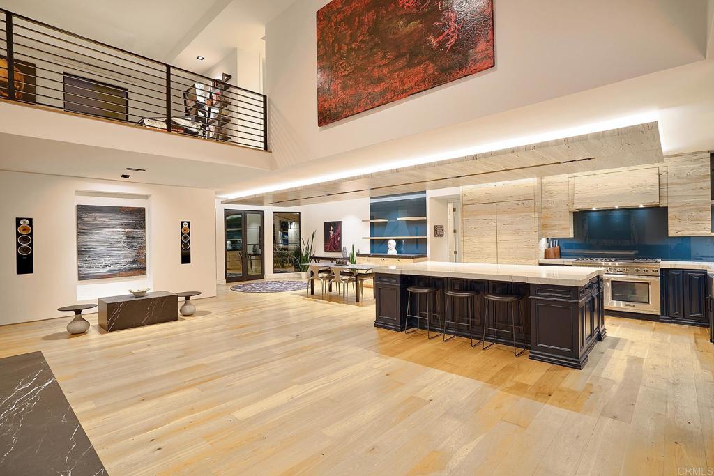 Open-concept great room with balcony overlook and hardwood floors