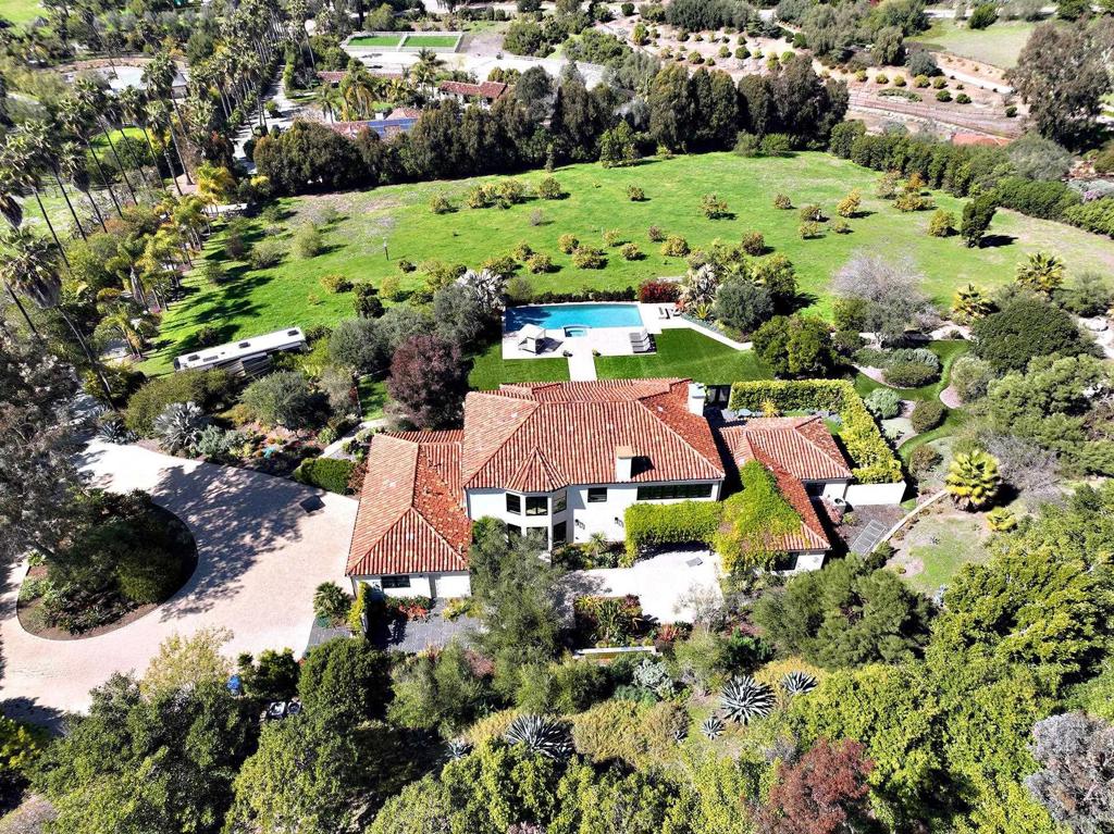 Aerial view of a luxury estate with pool and surrounding greenery