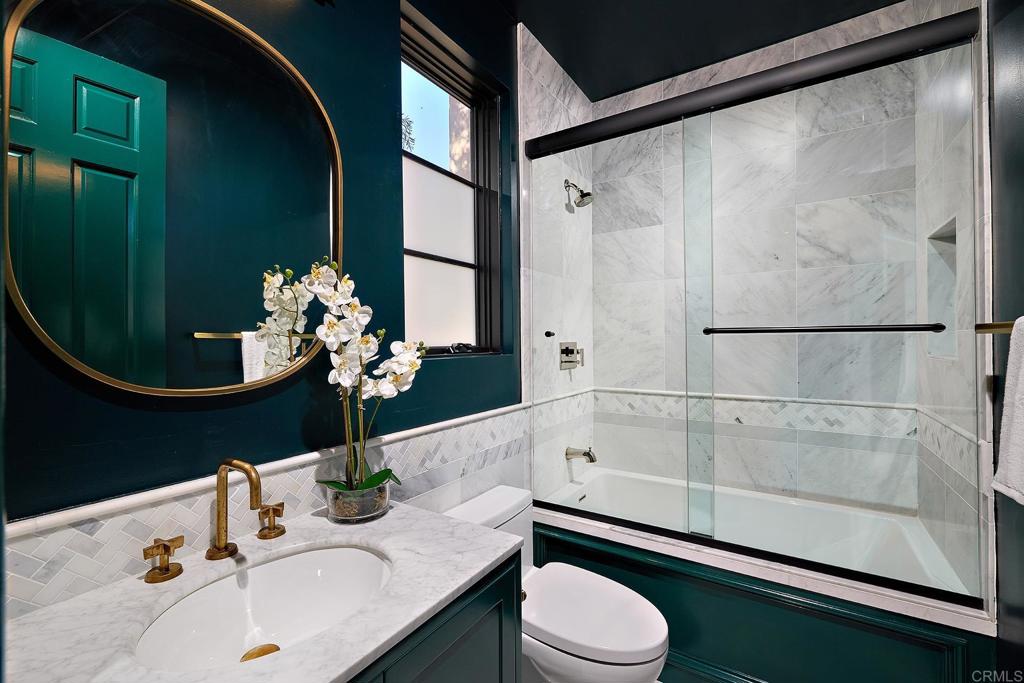 Elegant bathroom with green accent wall and marble shower