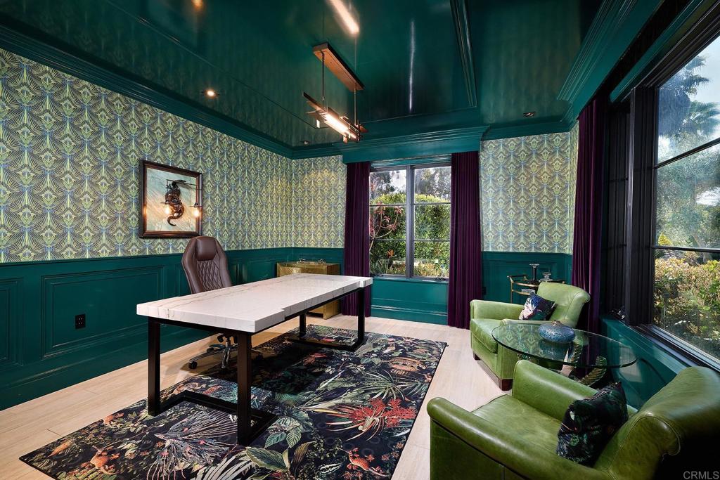 Green executive home office with patterned wallpaper and exterior views