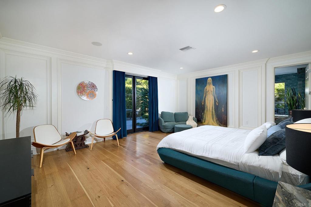 Spacious modern bedroom with large windows and wood flooring