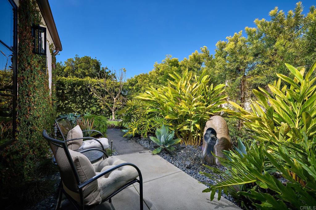 Garden pathway surrounded by tropical plants and outdoor seating
