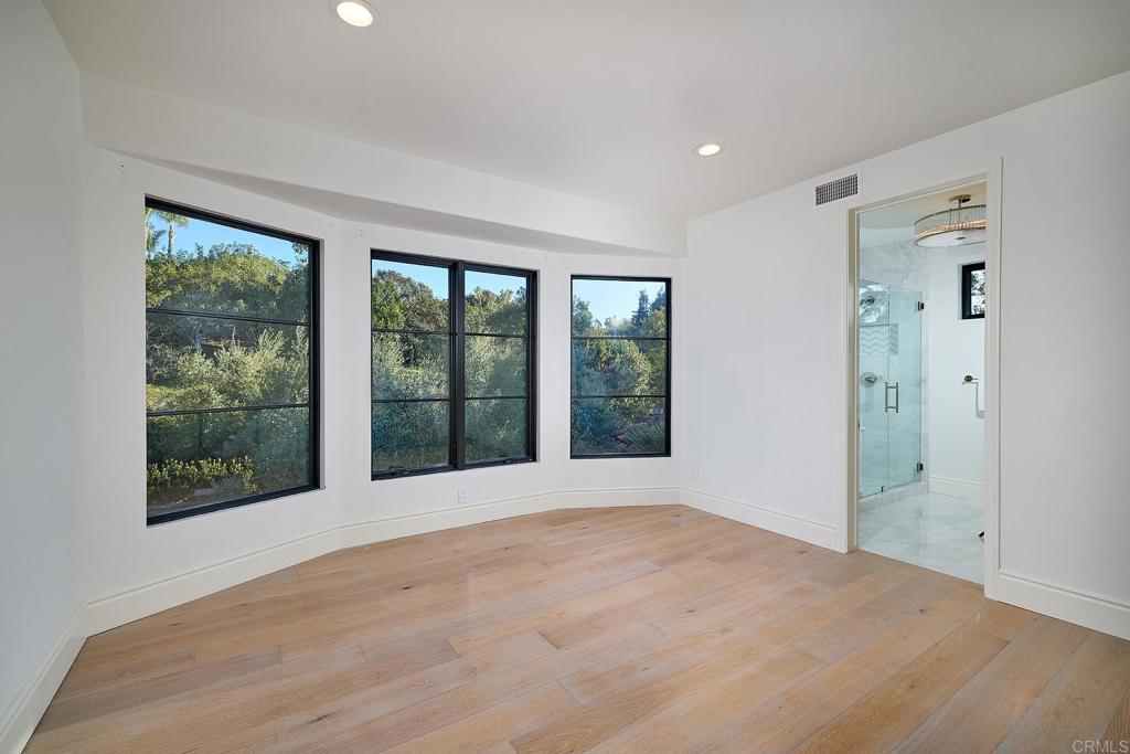 Bright bedroom with corner windows and an attached bathroom