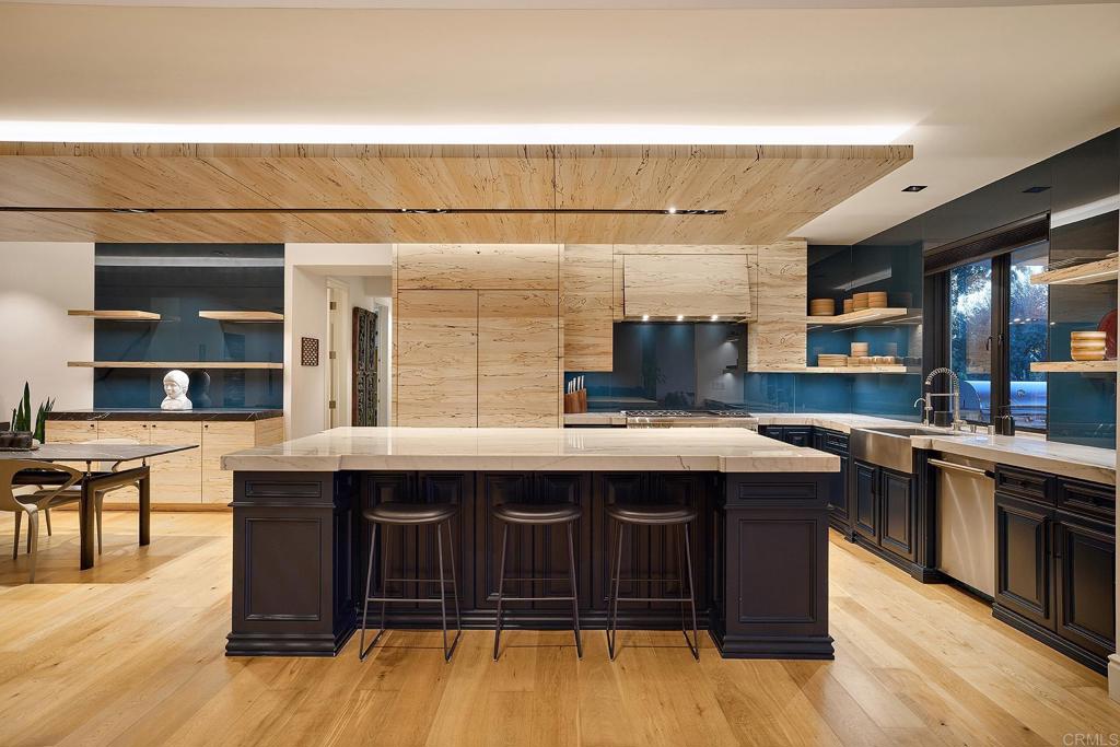 Chef’s kitchen with dark island and natural wood cabinetry
