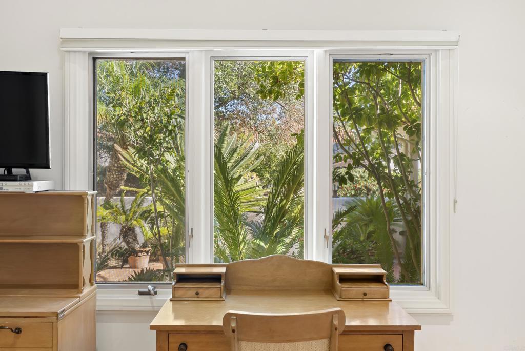 Reading nook with desk area and window views of lush landscaping