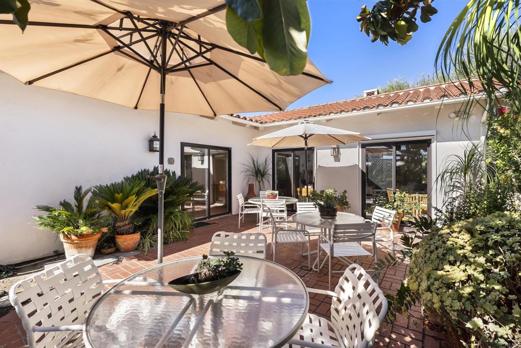 Private outdoor dining area with umbrella and garden views