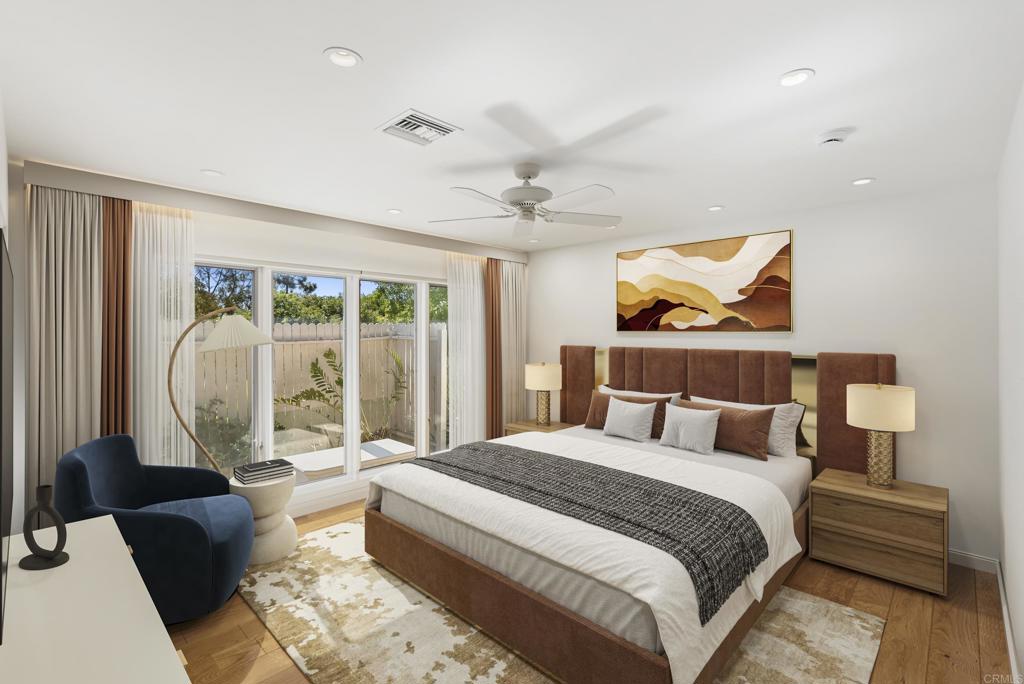 Spacious primary bedroom with large windows, modern decor, and a comfortable king-size bed