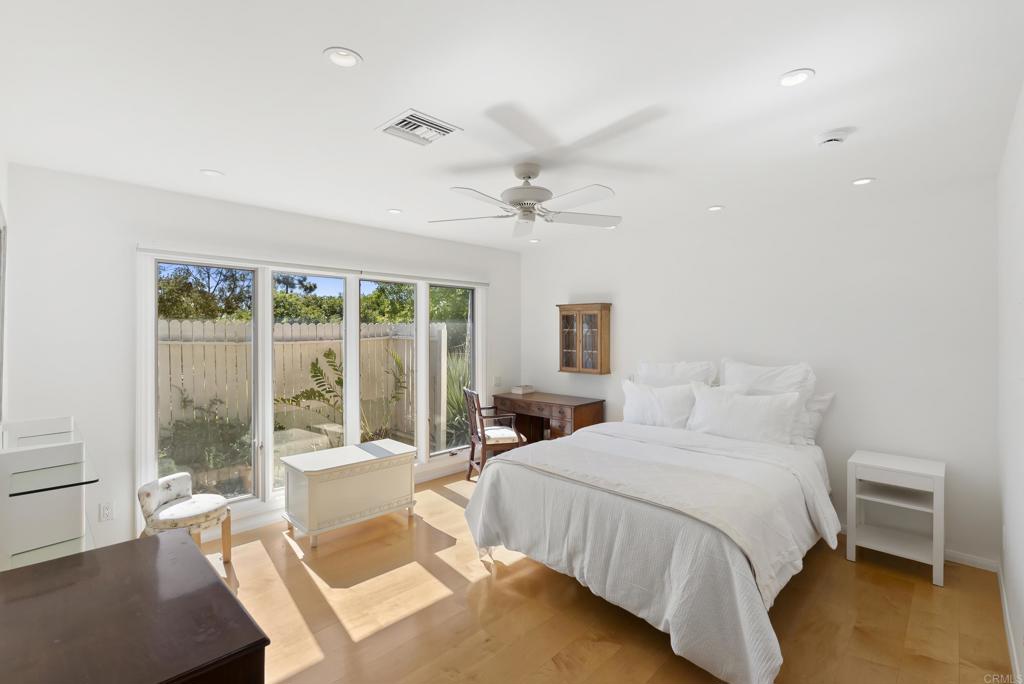 Bright primary bedroom with large windows and garden views