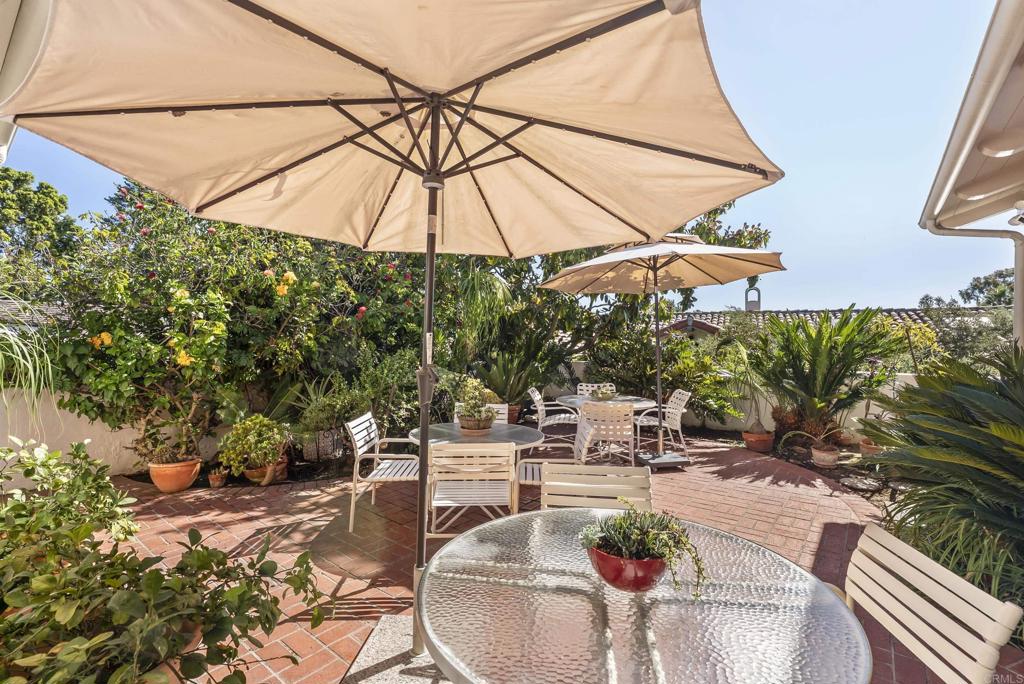 Outdoor dining patio with umbrella and garden surroundings