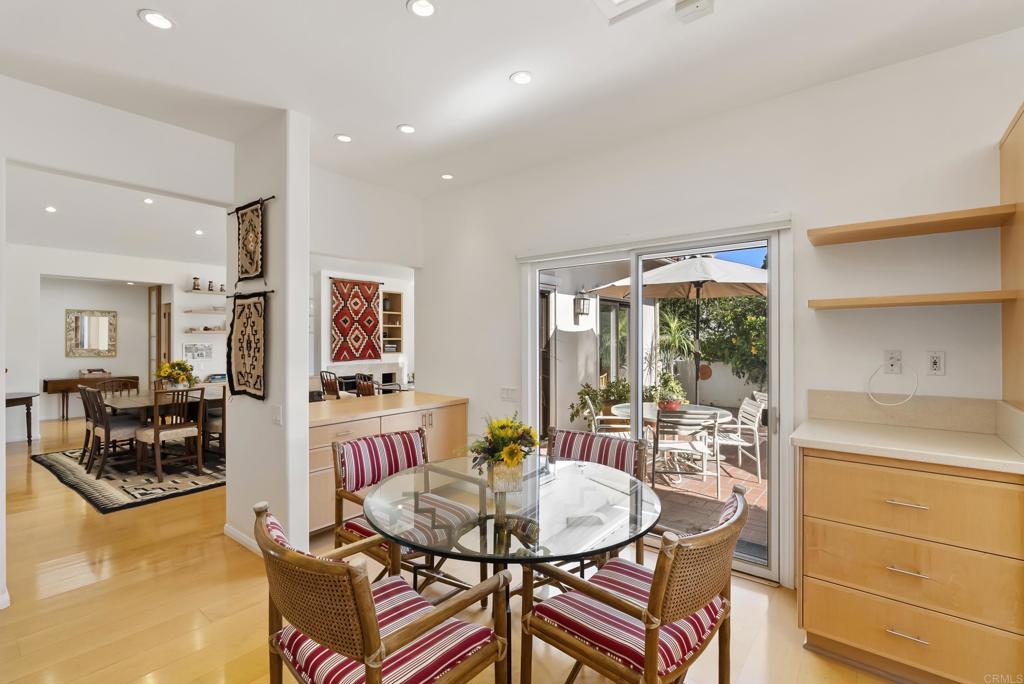 Cozy dining nook with round glass table, patterned chairs, and sliding doors to outdoor patio
