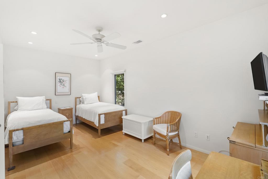 Guest bedroom with hardwood floors and natural light