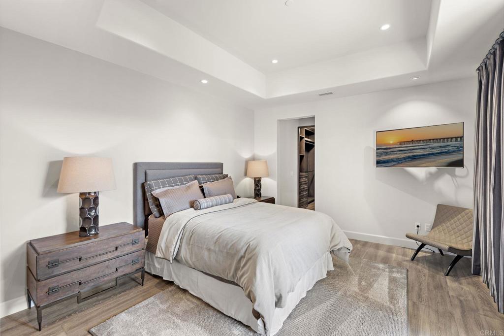Primary bedroom with tray ceiling and soft natural light