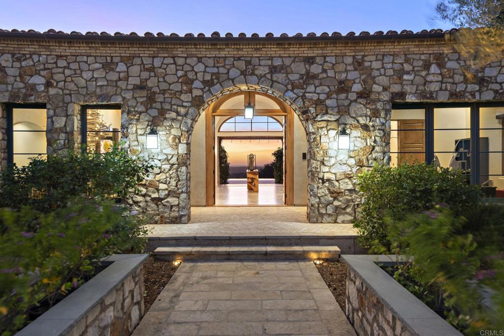 Elegant stone arch entryway of Santaluz custom estate