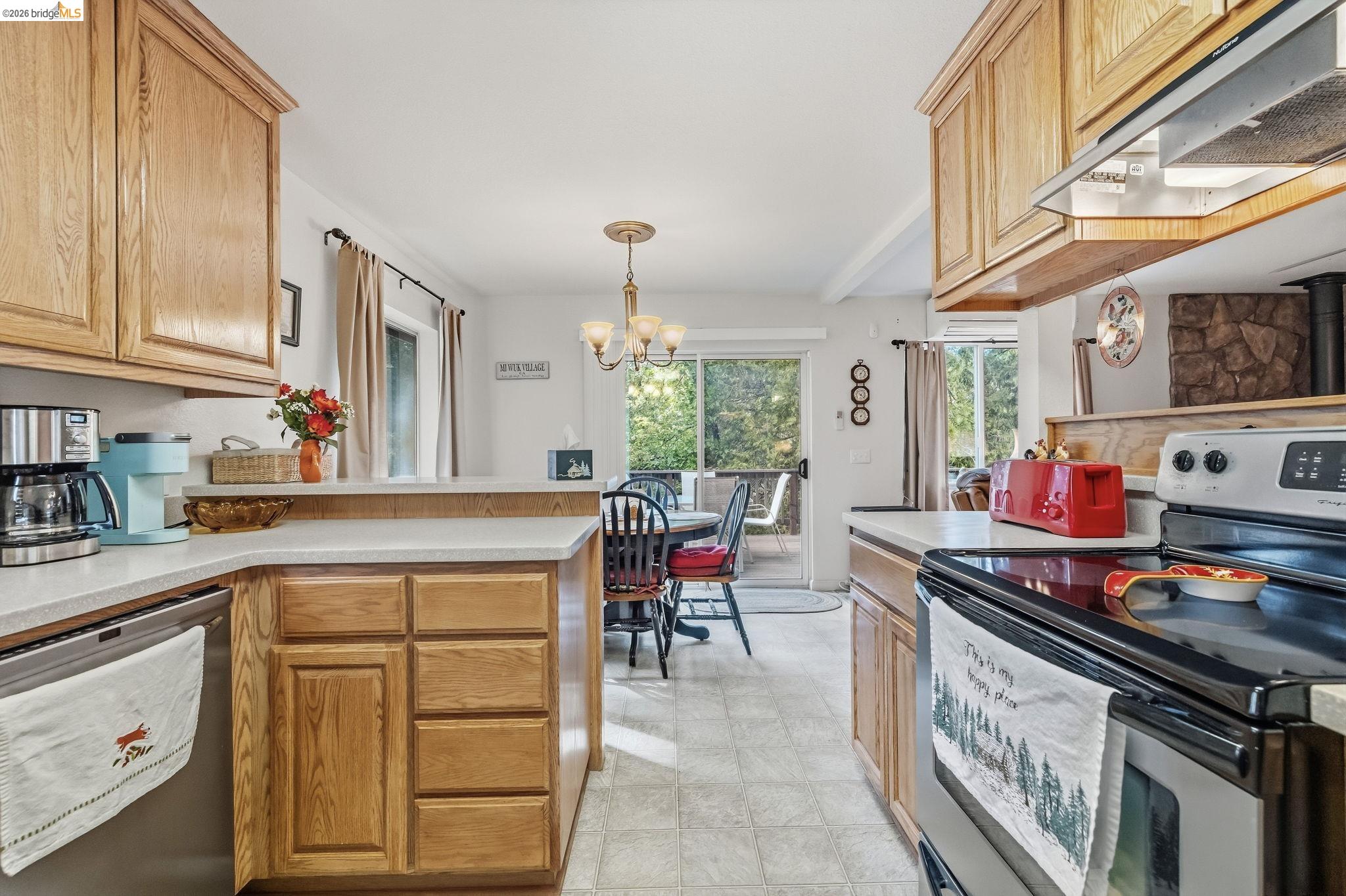 Kitchen with oak cabinets and island, dining area, and sliding glass doors to a deck.