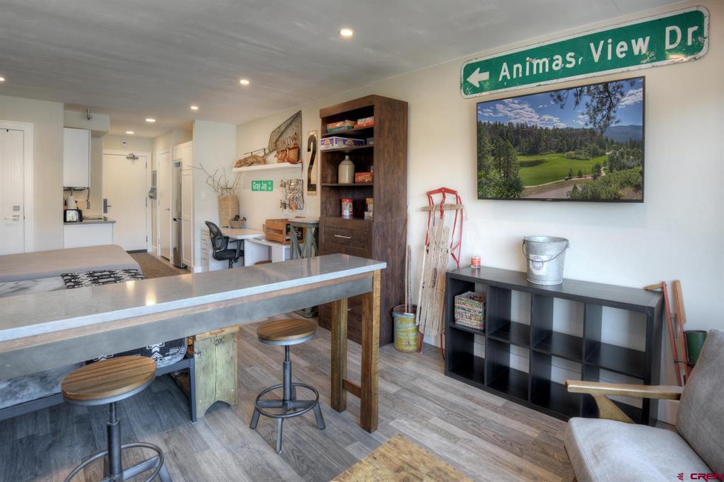 Furnished condo living area with a long breakfast bar, compact kitchenette, and Animas View Dr street sign.