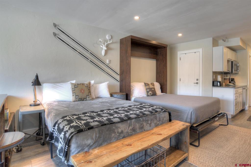 Bedroom with two beds, ski decor, and a compact kitchenette.