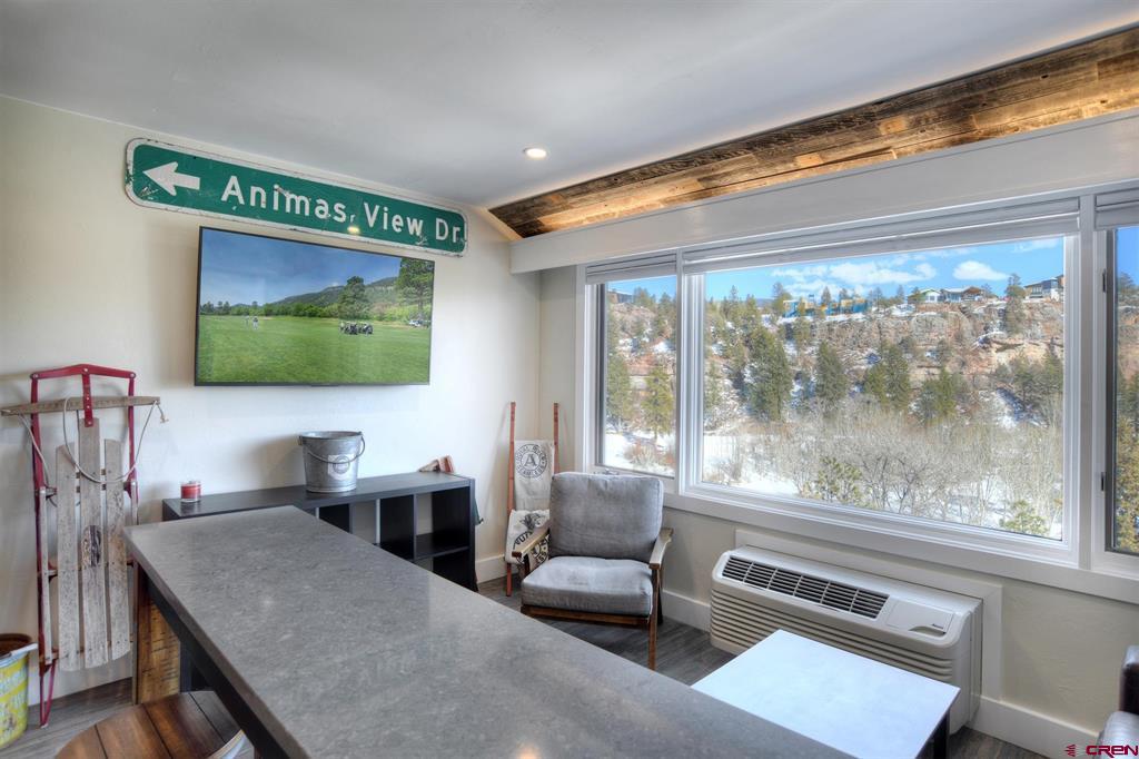 Interior with a long stone counter and large windows overlooking a snowy mountain hillside.