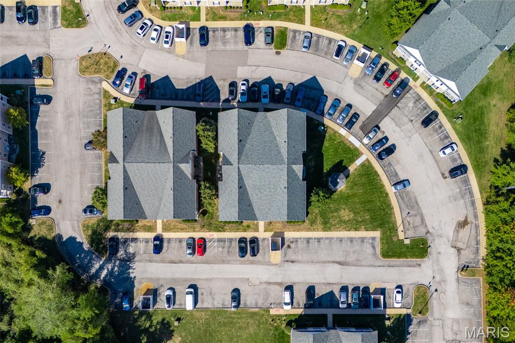 Aerial view of two condominium buildings surrounded by parking lots and landscaped grounds.
