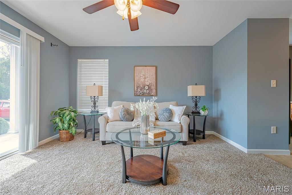 Furnished living room with a light sofa, glass coffee table, and blue-gray walls.