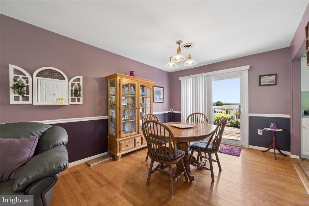 Dining room with a wooden table and china cabinet beside a sliding glass door to the deck.