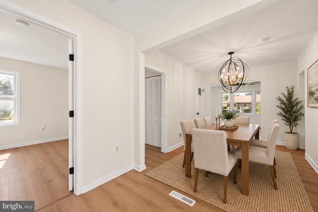 Staged dining room with a wood table, upholstered chairs, and a globe chandelier.