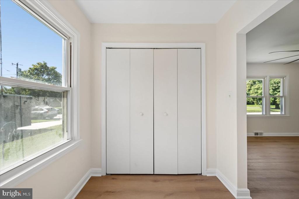 Bright room with a four-panel closet, light wood floors, and a large window.