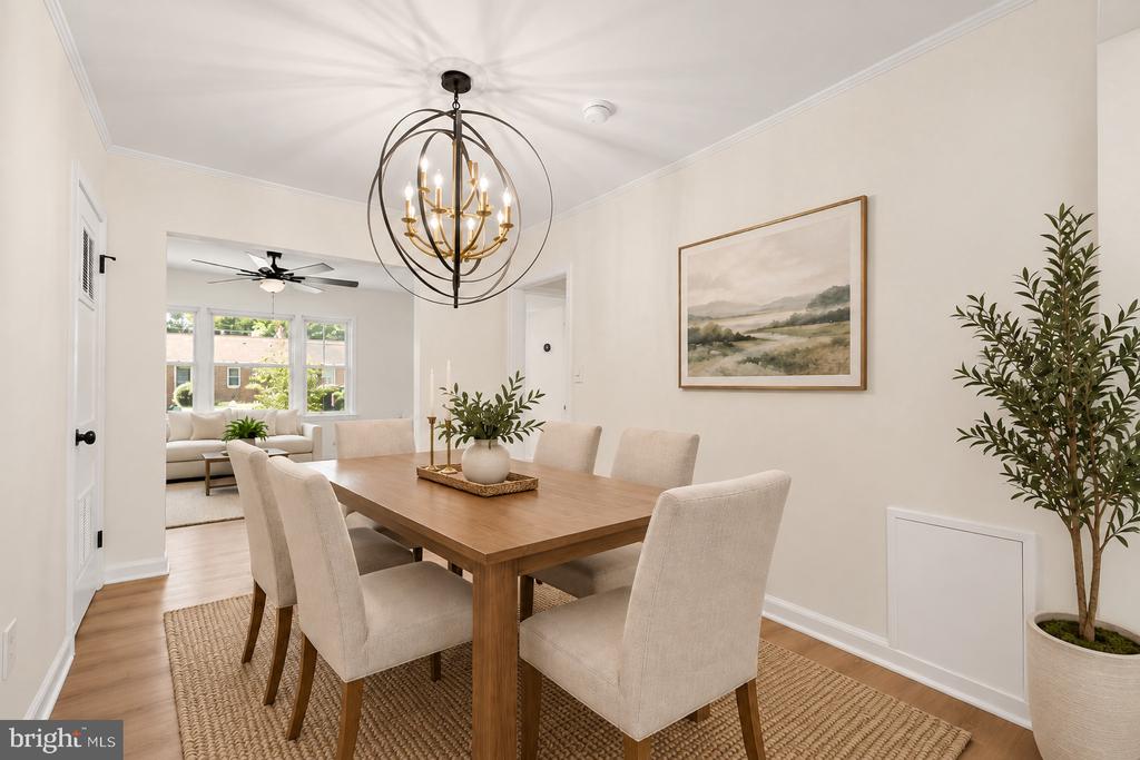 Dining room with a wood table, upholstered chairs, and a distinctive spherical chandelier.