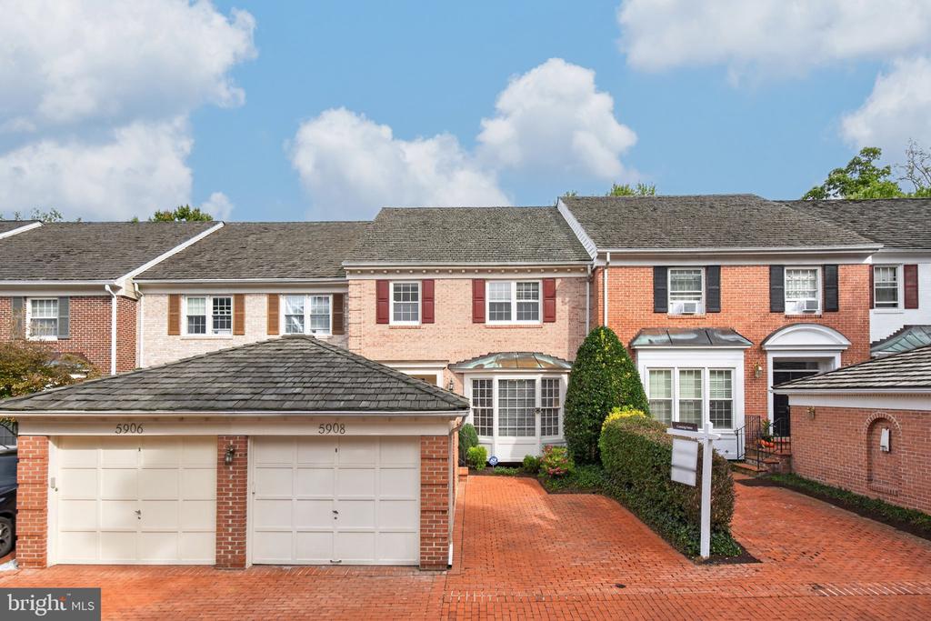 Brick townhouse with attached garage and red-brick driveway at 5908 Maplewood Park Place.