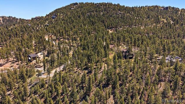 Aerial view of homes scattered across a forested mountain hillside.