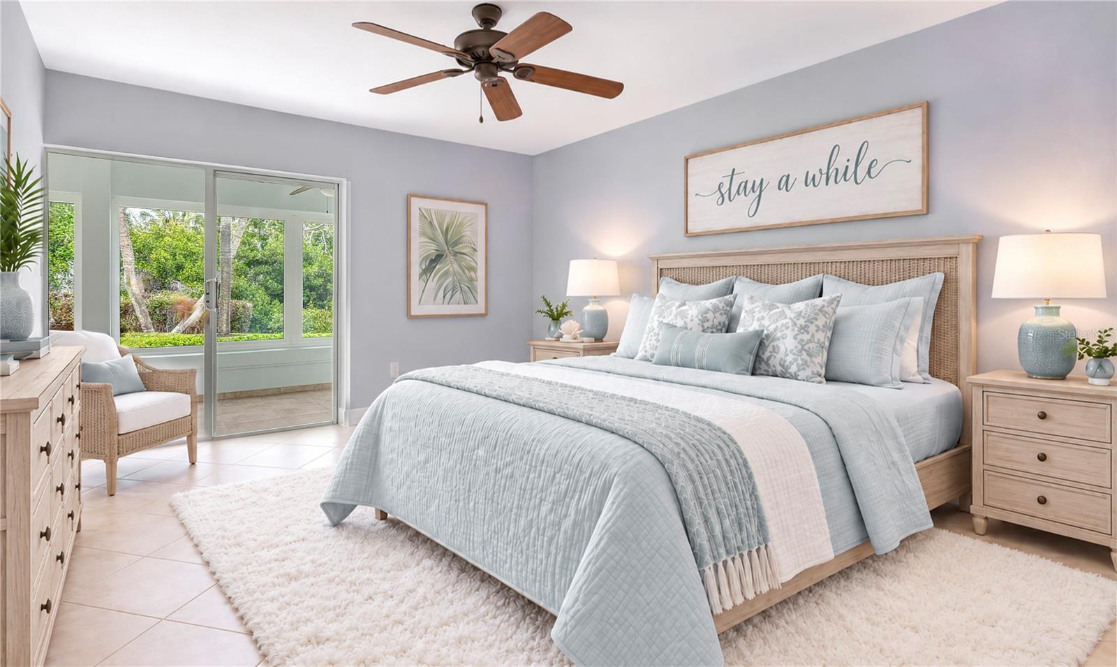 Staged bedroom with pale blue bedding, a woven headboard, and sliding doors overlooking greenery.