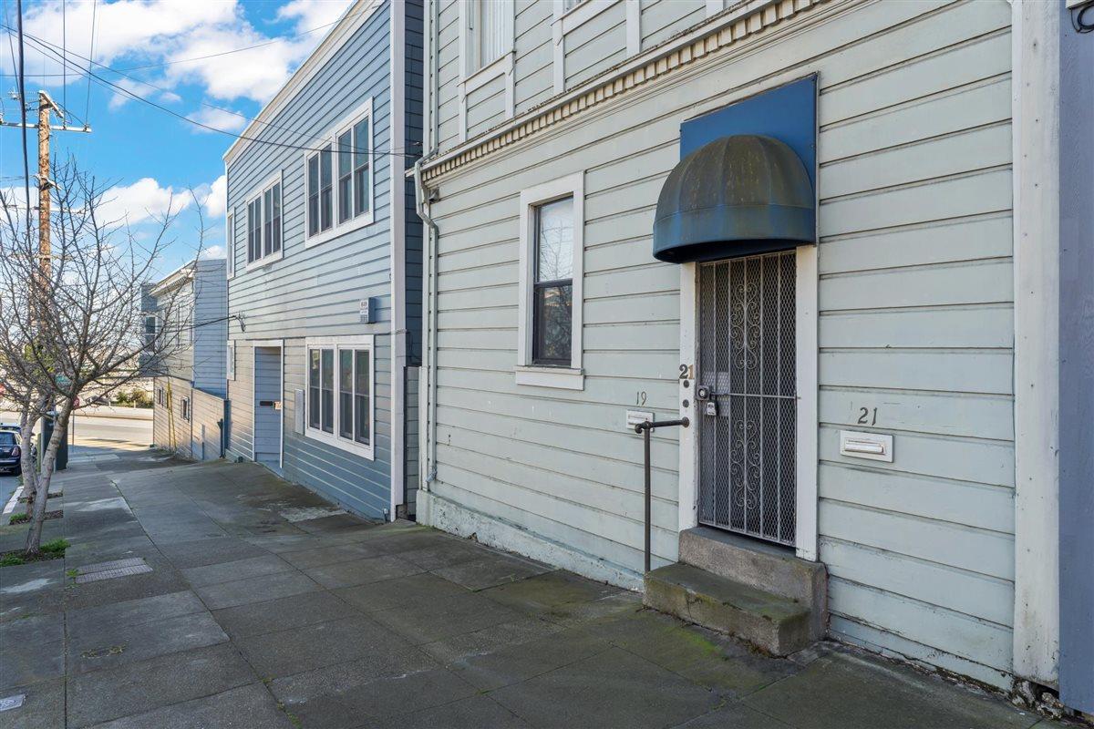 Wood-sided residence at 19 Joost Avenue, with a gated entry and sloping sidewalk.