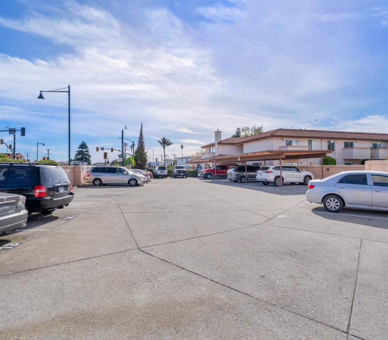 Multifamily property parking lot with covered parking and a two-story building.