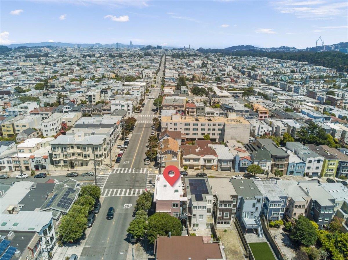 Aerial view of a San Francisco neighborhood, with a red marker over a rooftop near a street intersection.