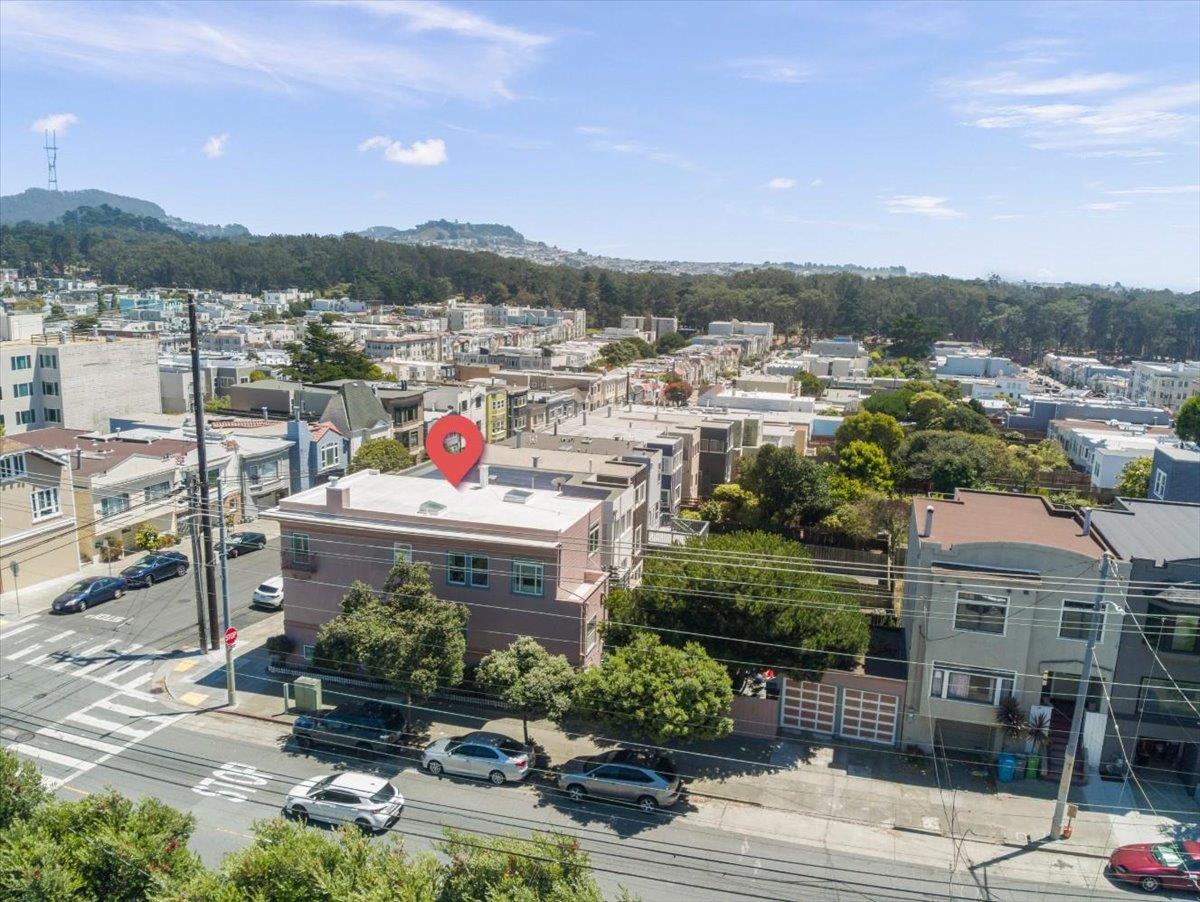 Aerial view of a flat-roofed multifamily building at a San Francisco street corner, marked with a red pin.