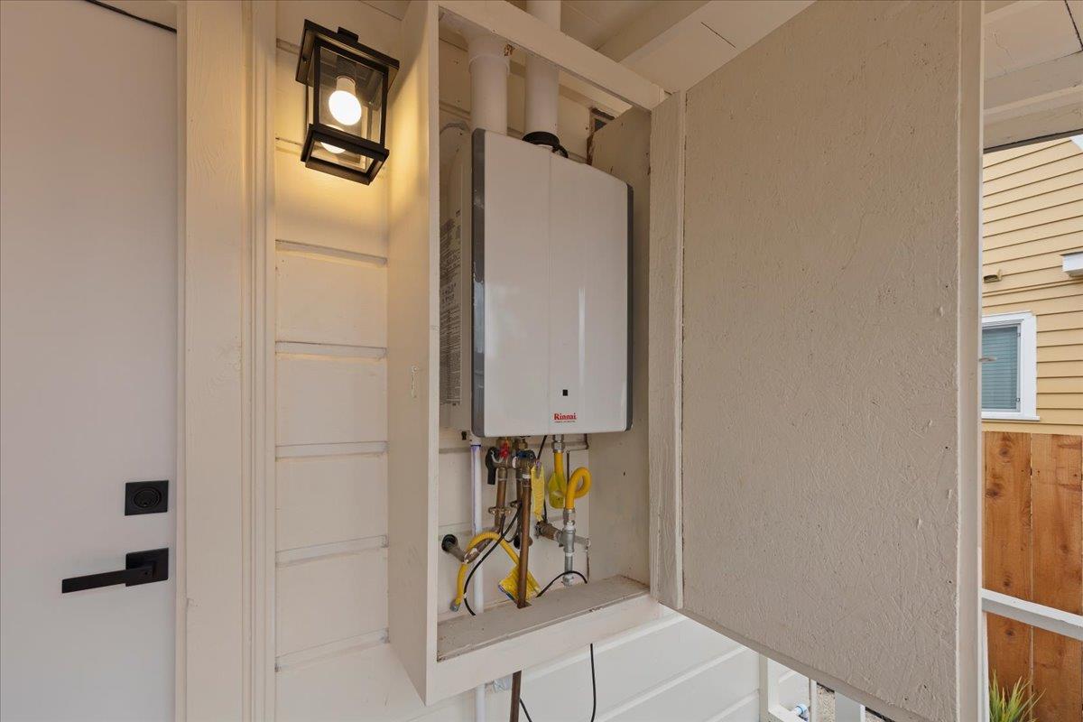 Tankless water heater in an exterior utility cabinet beside a doorway.